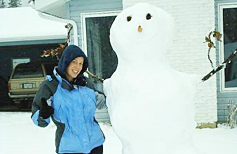Snowman standing beside woman.
