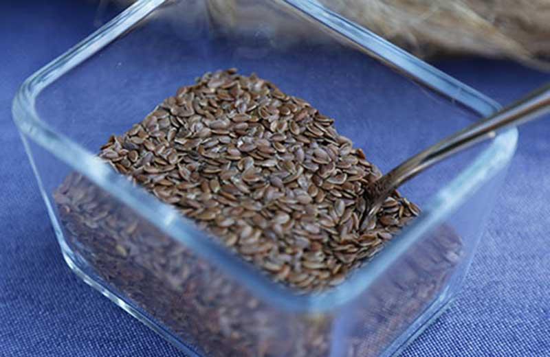 Flax seeds in a glass container dish.