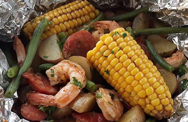 Shrimp, corn, potatoes in tin foil.