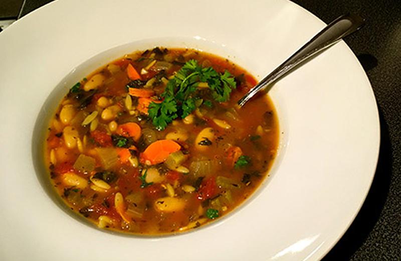 Home made soup in a white bowl with a spoon