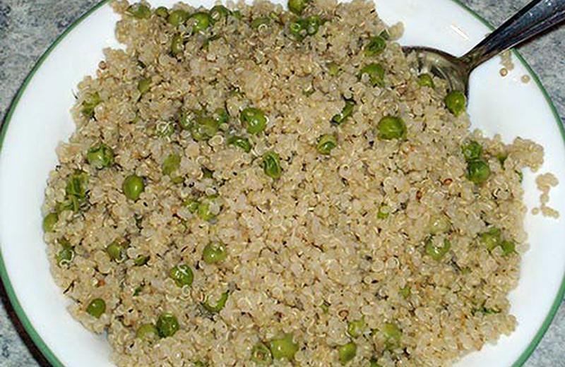 Bowl of cooked quinoa and green peas