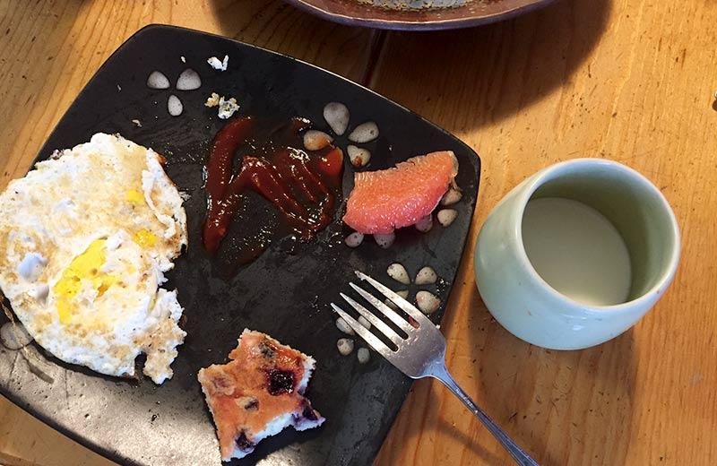 A half-eaten breakfast sits on a plate.
