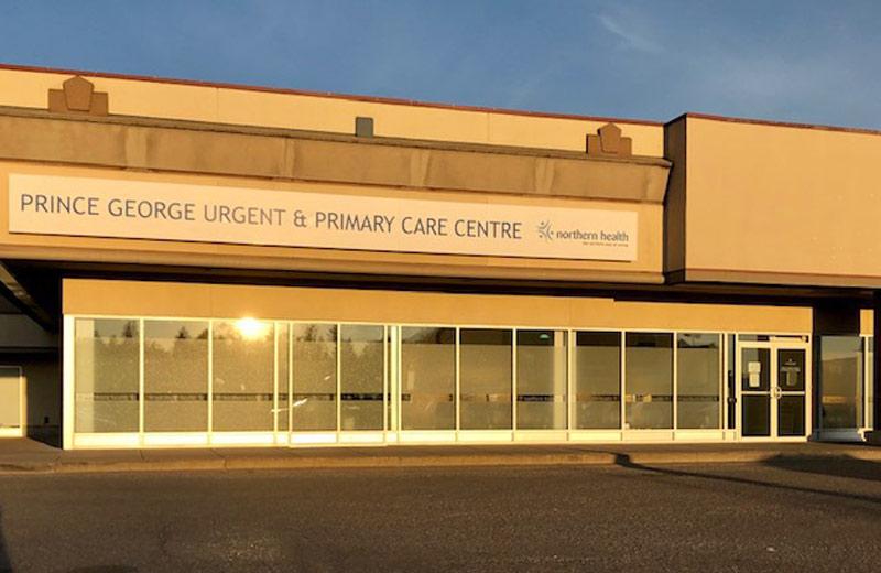 A one-story clinic that is part of a strip mall at sunset.