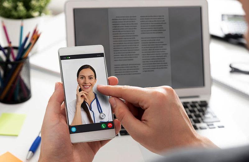 A female doctor is on a video call on a phone. 