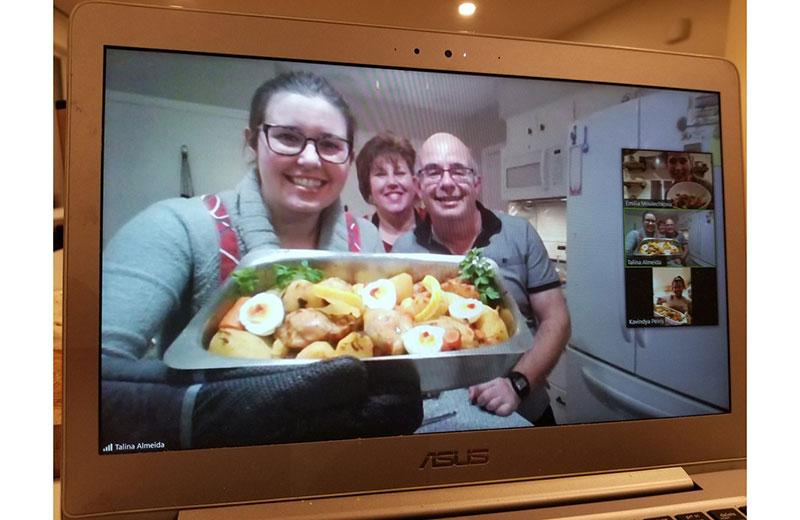 Laptop screen shows family displaying food they made.