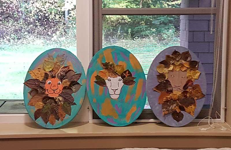 3 oval crafts that depict lions on a windowsill