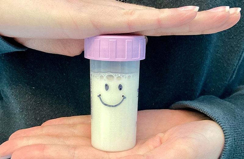 Small vial of human milk with a smiley face