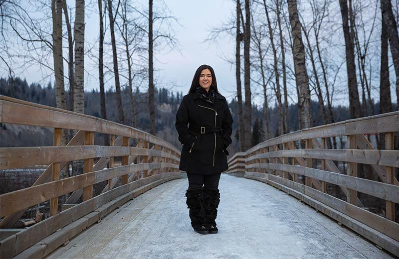 Indigenous woman standing on a bridge 