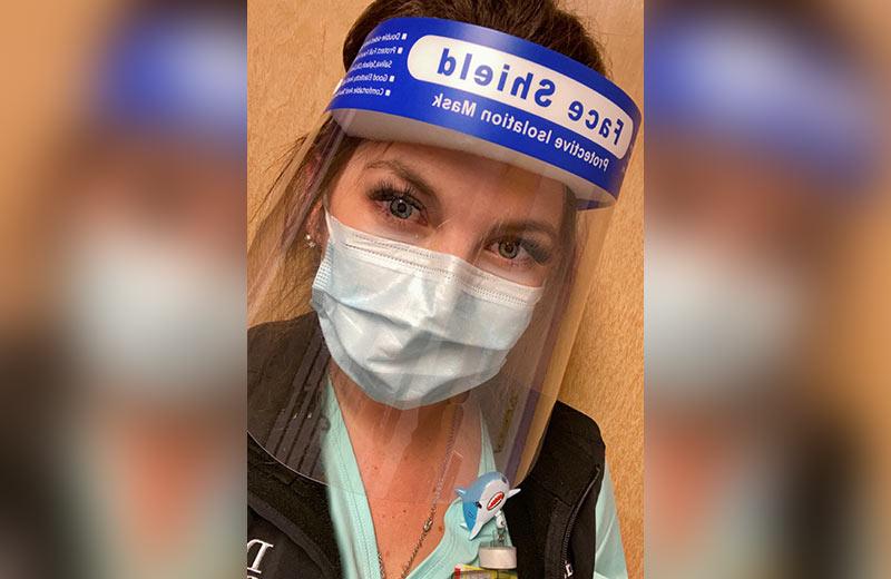 Registered nurse wearing a face mask and face shield.