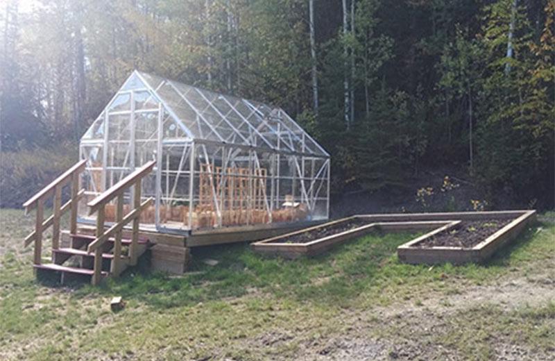 Greenhouse with stairs and a raised garden bed on the right