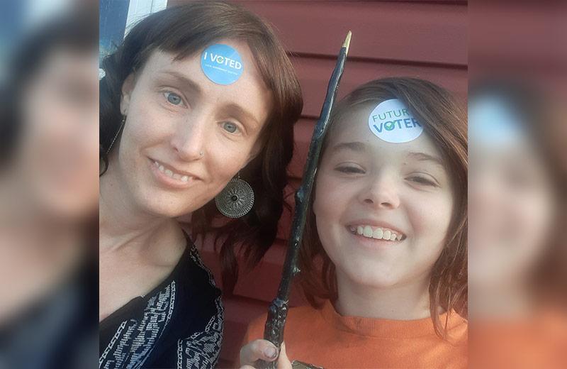 Woman and her son with voter stickers on their foreheads.