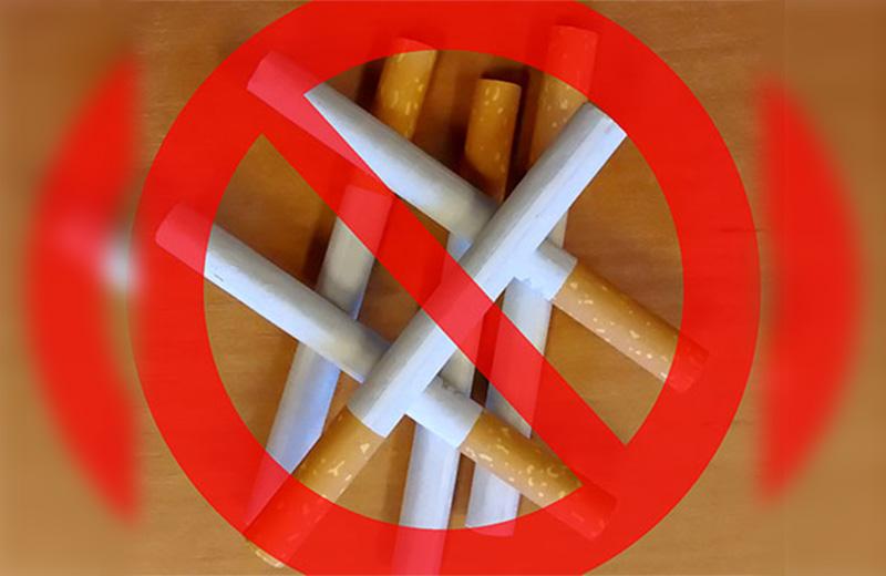 Pile of cigarettes with red ban crossing over top