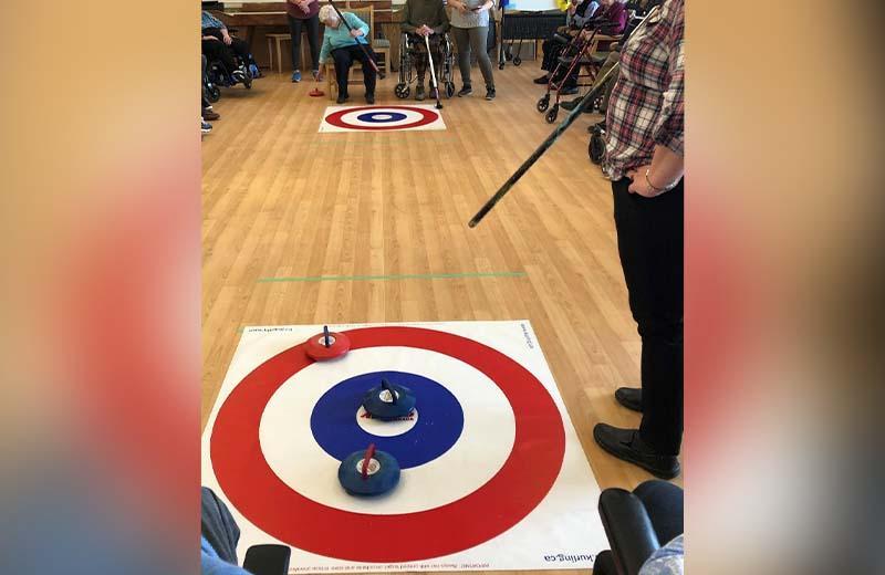 Seniors play indoor curling game