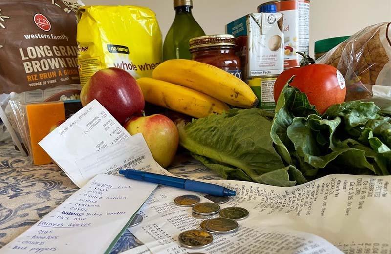 an array of groceries sits on a counter with some change in front 