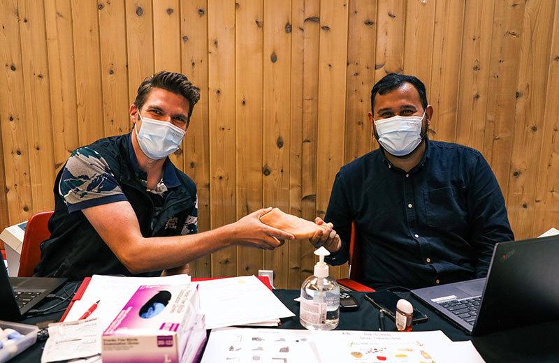 Two men with masks work at a health clinic