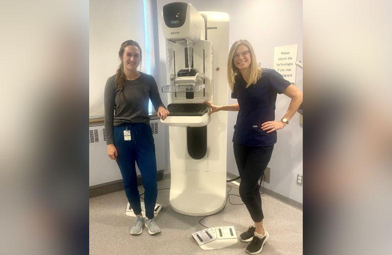 Meagan Warner and Rebecca White, mammography technologists, posing with mammogram  equipment