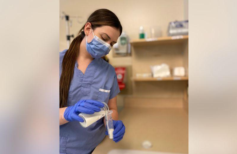 NICU nurse Emily Fetterly prepares to feed pasteurized donor human milk to a baby in the NICU