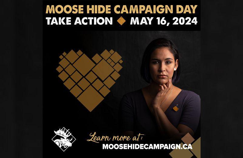 An indigenous woman stands beside a tan heart made from multiple moose hide squares. Campaign poster. 