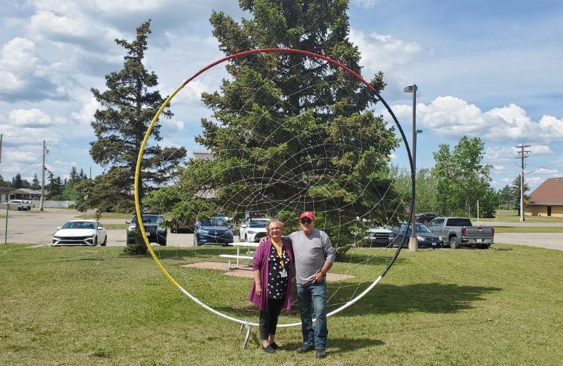 Margaret McGillis and Stan Fraser standing outside DCDH, in front standing in front of a the dreamcatcher