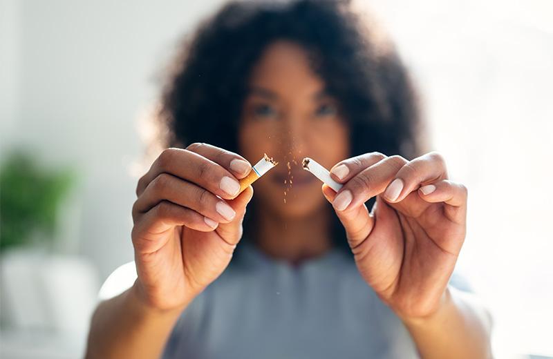 A woman breaks a cigarette in half