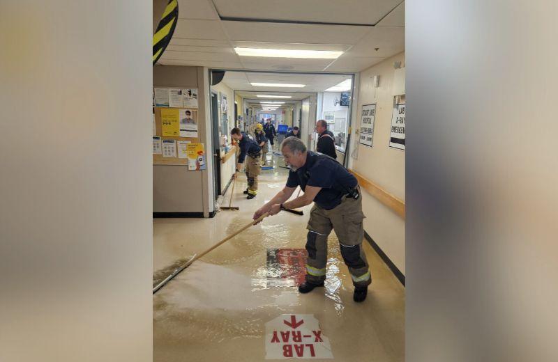 Fire fighters mop and  puch water downt he hallways of the Stuart Lake Hospital during clean up efforts