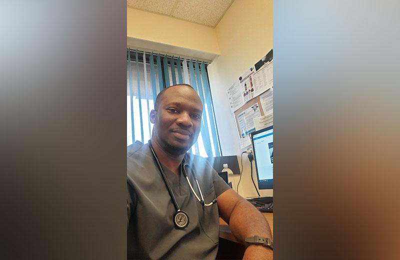 Man in scrubs in a medical office.