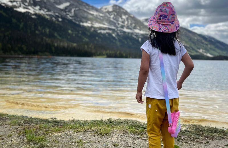 A child llooks out over a lake