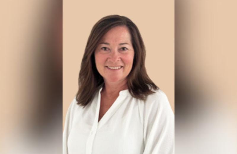 Woman with shoulder length brown hair smiles in portrait.