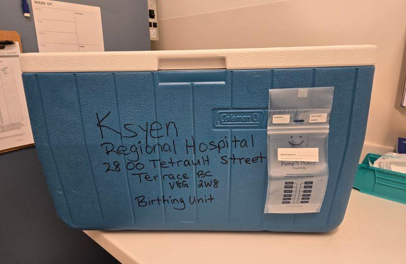 A blue cooler containing human milk donations in transport