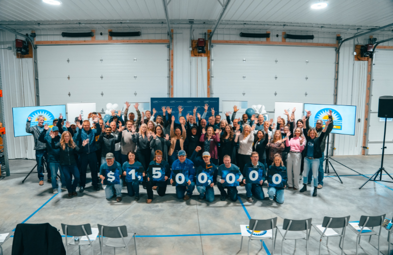 Group of people stand behind sign that reads 1.5 million dollars