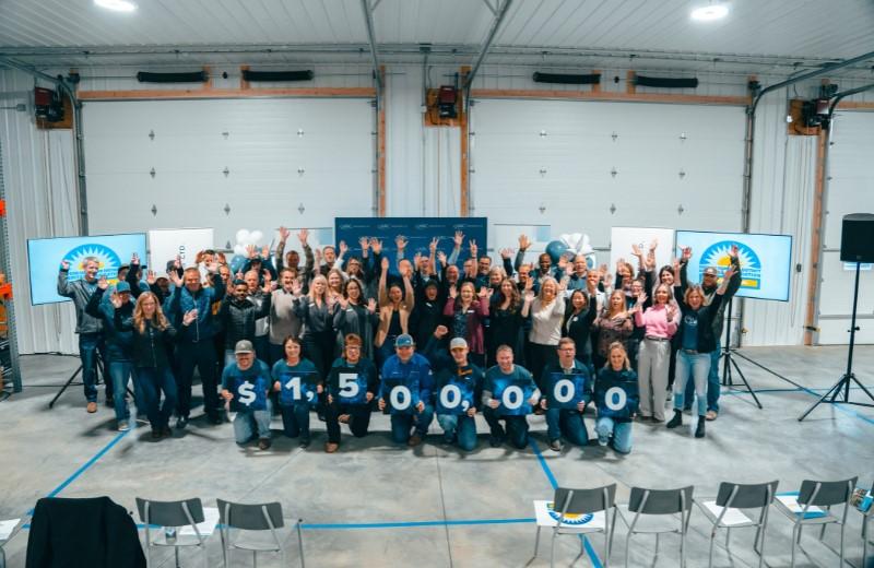 Group of people stand behind sign that reads 1.5 million dollars