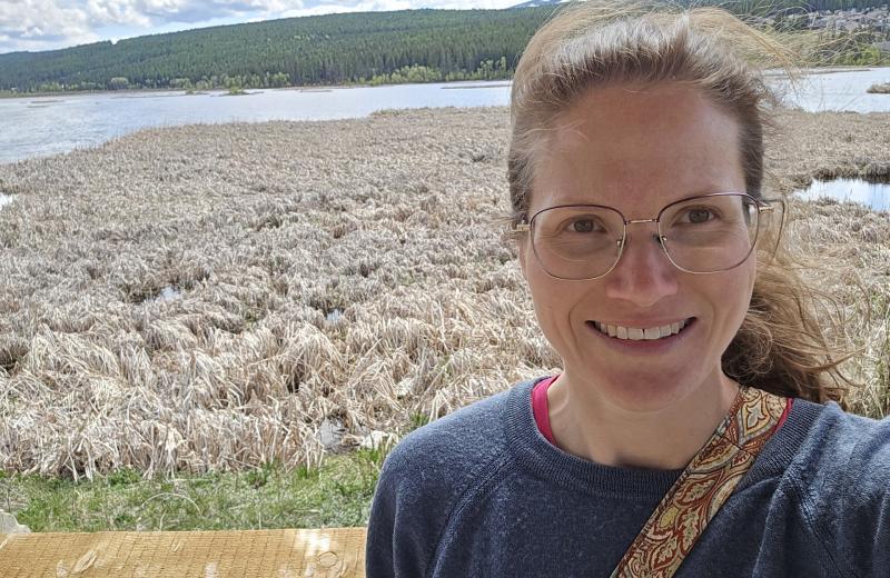 Courtenay standing at a lake