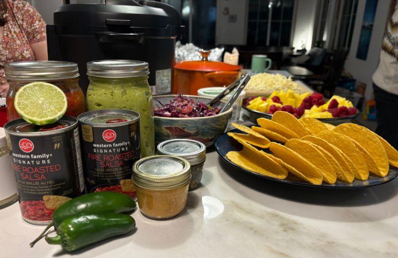 Ingredients for a taco buffet are laid out on a kitchen counter.