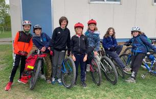 Group of students standing beside their bikes at school. 