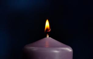 A lit purple candle. The symbol of IOAD