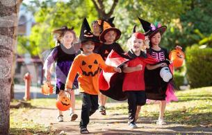 Kids running in costume to collect candy. 