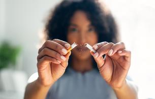 A woman breaks a cigarette in half