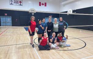 Athletes pose in the middle of a school gym