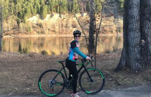 Gloria standing with her bike with the Fraser river in the background