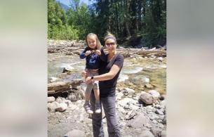 Katie Trites and her daughter Layla standing next to a river