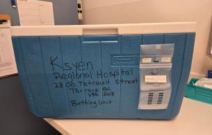 A blue cooler containing human milk donations in transport