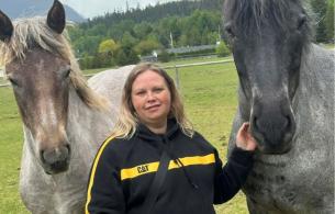 Nicole standing with 2 horses