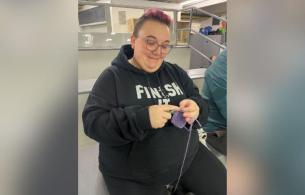 woman knitting in bleachers at hockey game.