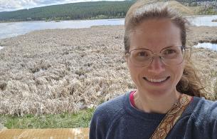 Courtenay standing at a lake