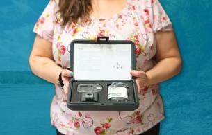 Person stands holding a holter monitor